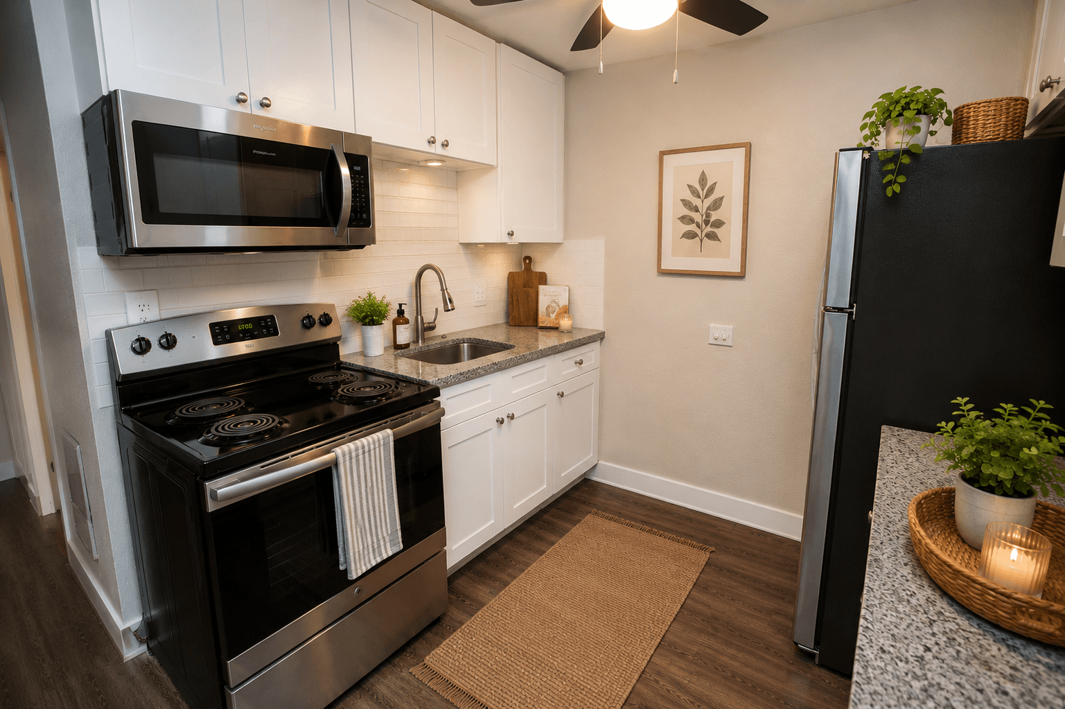 A modern kitchen with a black stove top oven and white cabinets.